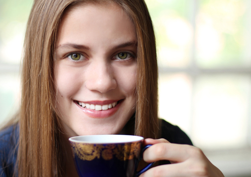 why-childs-wisdom-teeth_34165862 A young woman holding a cup of coffee.