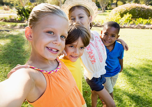 crown_baby_tooth A group of children taking a selfie in a park.