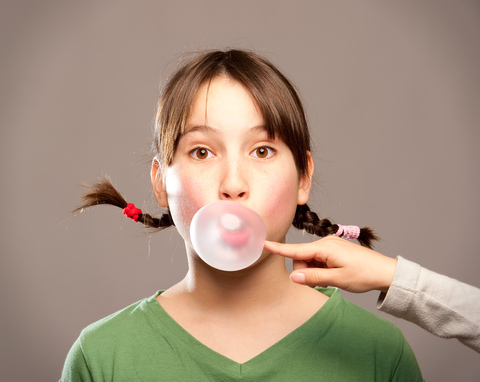 dental-chewinggum A girl blowing a bubble on her finger.