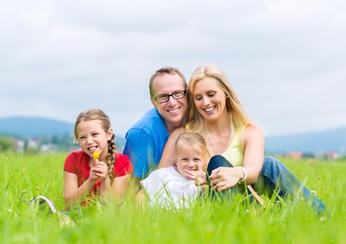 family-resting-on-grass_33399819 A family is sitting in a grassy field.