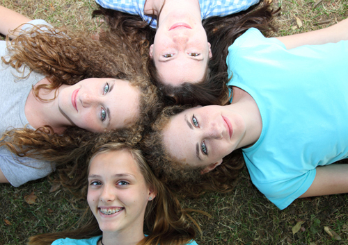A group of girls laying on the ground.