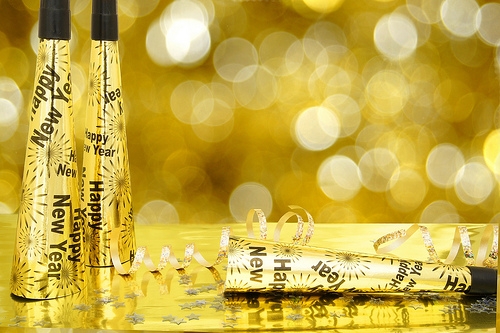 holiday-new-year-2 Two gold new year's confetti cans on a gold background.