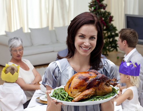 holiday-thanksgiving-womanandturkey A woman holding a turkey on a plate.