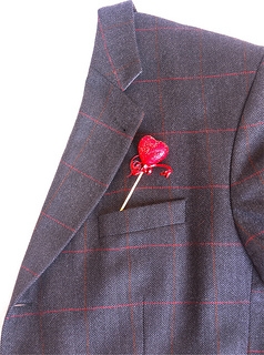 A lapel pin with a red heart on it.