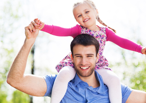 how-safe-dental-x-rays A man is holding a little girl on his shoulders.