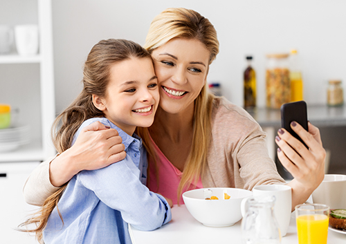 impacted_child_tooth2 A mother and daughter taking a selfie in the kitchen.