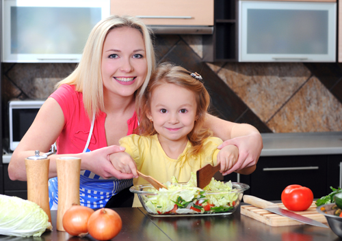 mom-and-daughter-in-kitchen_32536938 A woman and a little girl in a kitchen.