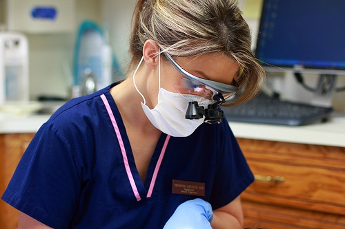 ortho-assistant-glasses A female dentist wearing a mask and gloves.