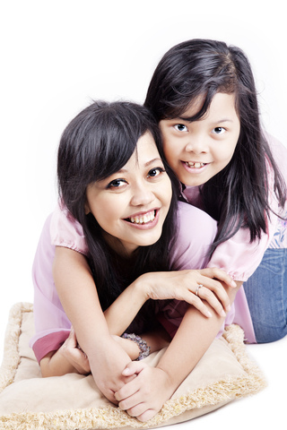 Two young girls laying on a pillow.