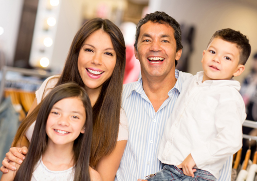 parents-prevent-tooth-decay A family is posing for a photo in a clothing store.