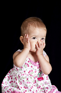 pedo-baby-shy A little girl wearing a pink and white dress.