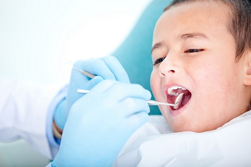 pedo-boy-exam A young boy is getting his teeth checked by a dentist.