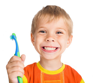 A boy holding a toothbrush.