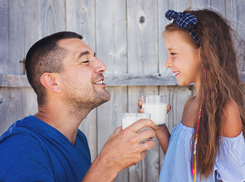perks_dairy_xl_87499625 A man and a girl drinking milk.