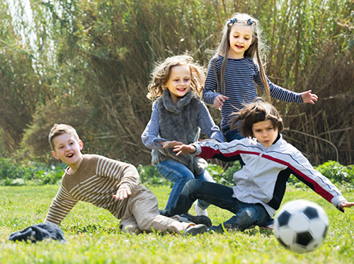 A group of children playing with a soccer ball.