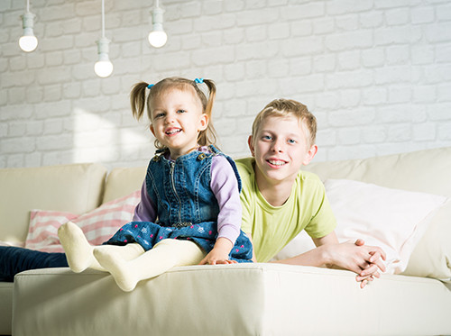 right_dental_child_xl_87859617 A girl and boy sitting on a couch.