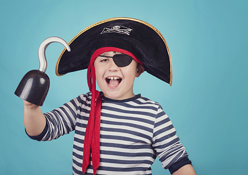 A boy wearing a pirate hat and holding a hook.